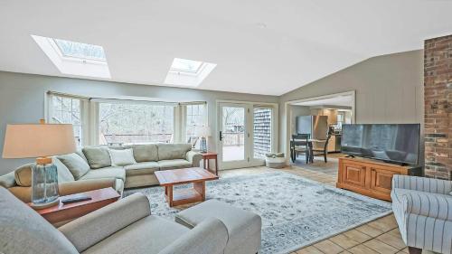 un salon avec un canapé et une télévision dans l'établissement Stay On The Cape Vacation Rentals Cape Cod Getaway Near Beaches & Bike Trail, à Eastham