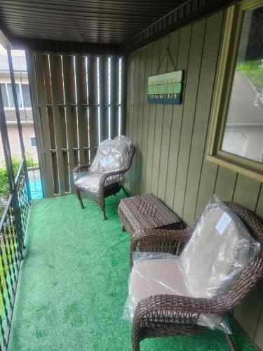 a porch with two wicker chairs and a table at Super Comfy Entire Home in Scranton