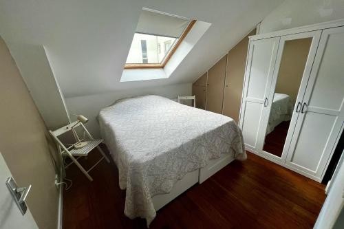 une petite chambre avec un lit et un miroir dans l'établissement Charming 2 rooms near hypercenter, à Nantes