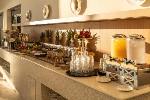 a buffet line with food and drinks on a counter at Valmar Corfu in Agios Ioannis Peristeron