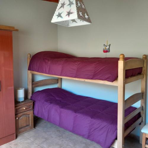 a bedroom with two bunk beds with purple sheets at Lugar de PAZ en las Sierras in Sierra de la Ventana
