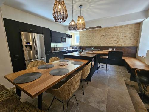 une cuisine avec une grande table et des chaises en bois dans l'établissement LA MAISON VALENTIN AU COEUR DE LA CITE MEDIEVALE, à Sarlat-la-Canéda