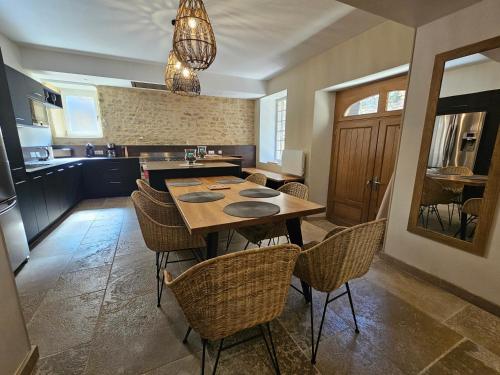 une cuisine avec une table et des chaises en bois dans l'établissement LA MAISON VALENTIN AU COEUR DE LA CITE MEDIEVALE, à Sarlat-la-Canéda