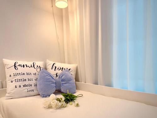 a bed with two pillows and flowers on it at HausKomma 서울 홍대,이태원,명동 짐보관 무료 주차 엘레베이터 새아파트 in Seoul