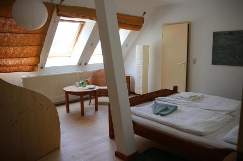 a small bedroom with a bed and a table at BIO-Hotel Kenners LandLust in Göhrde