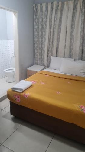 a bedroom with a large bed with flowers on it at Zurich garden lodge benoni in Benoni