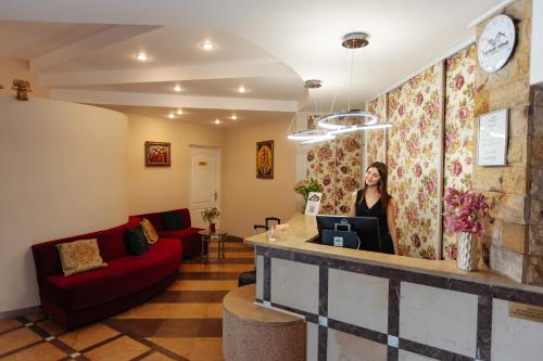 a woman standing at a counter in a room at Hotel Victory Home in Warsaw