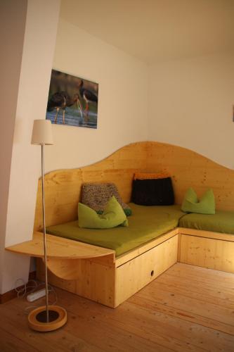 a wooden bed with green pillows in a room at BIO-Hotel Kenners LandLust in Göhrde