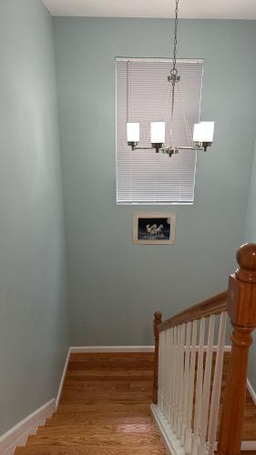 a room with a staircase with a window and a chandelier at Jamani house in Freeport