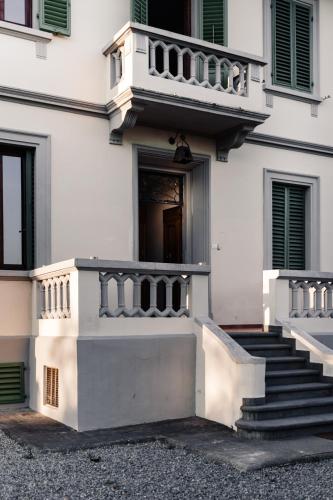 a white building with stairs and a balcony at Mugello Hostel in SantʼAgata