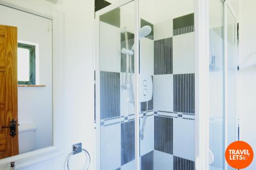 a bathroom with a shower with black and white tiles at Dudhil House in Letterkenny