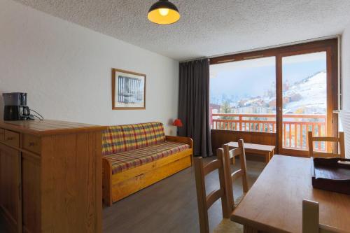ein Wohnzimmer mit Couch und Tisch und ein Balkon in der Unterkunft travelski home classic - Résidence Meijotel in Les Deux Alpes