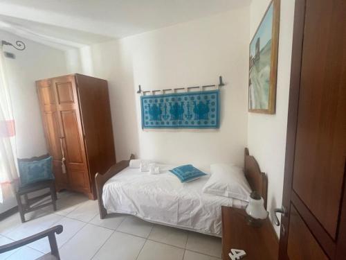 a small bedroom with a bed and a chair at Casa Ziranu Sa Domo e su Cantaru in Orani