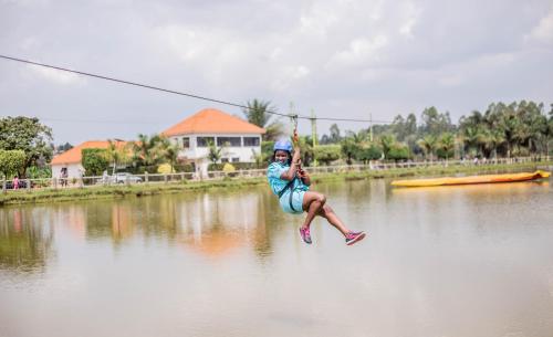 a person jumping in the water while holding onto a line at Forest Park Resort in Buloba