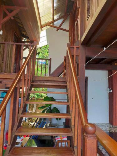 a wooden staircase in a house with a plant at Cham Island Wooden Cabin in Hoi An