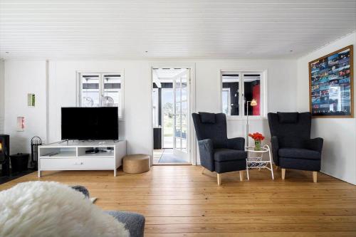 a living room with a television and two chairs at 350-Hvide-Sande-Fyrmarken-12 in Hvide Sande