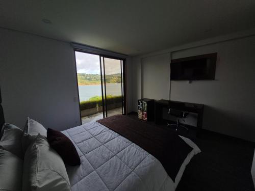 a bedroom with a bed and a large window at Casa el OLIVO in Club Las Anonimos