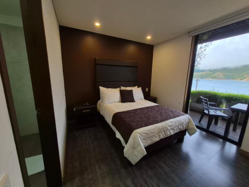 a bedroom with a bed with a view of the water at Casa el OLIVO in Club Las Anonimos