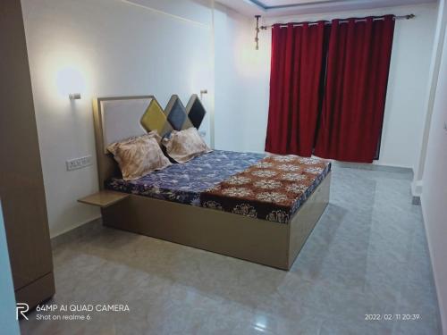 a bed in a room with a red curtain at Swapnapurti Holiday home in Lonavala