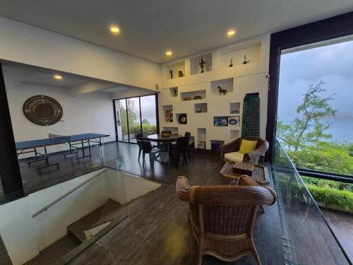 a living room with a table and chairs and a large window at Casa el OLIVO in Club Las Anonimos