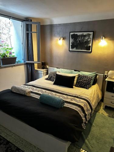 a bedroom with a large bed with pillows and a window at La Vannière in Le Poujol-sur-Orb