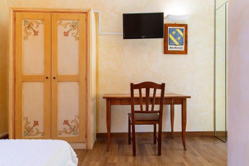 a room with a table and a chair and a television at Palazzo Cappa-Affitti Brevi Italia in LʼAquila