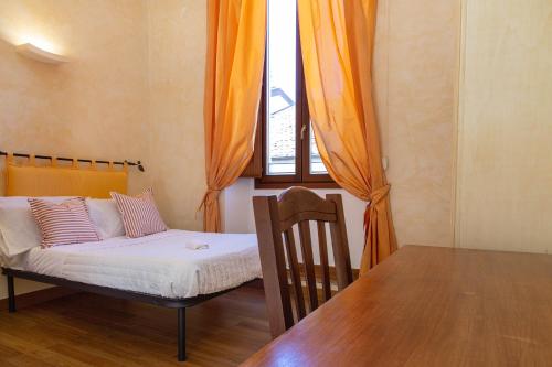 a bedroom with a bed and a table and a window at Palazzo Cappa-Affitti Brevi Italia in LʼAquila