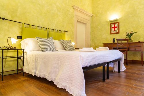 a bedroom with a large bed with white sheets at Palazzo Cappa-Affitti Brevi Italia in LʼAquila