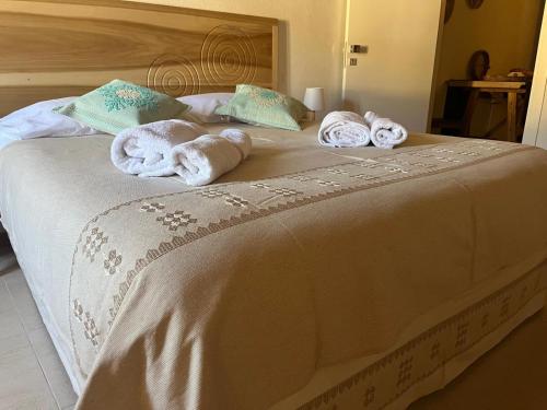 a bedroom with a bed with towels on it at Casa Ziranu Sa Domo e su Cantaru in Orani