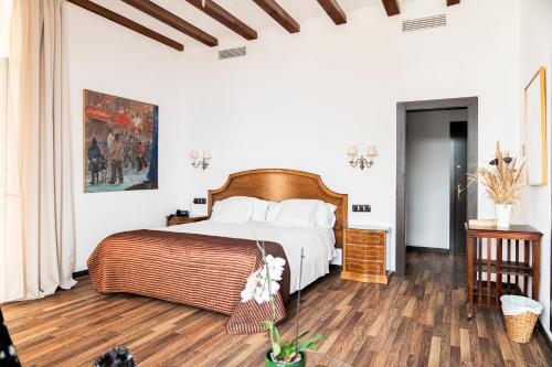 a bedroom with a large bed and a wooden floor at Hotel Roger de Flor by Seleqtta in Lloret de Mar