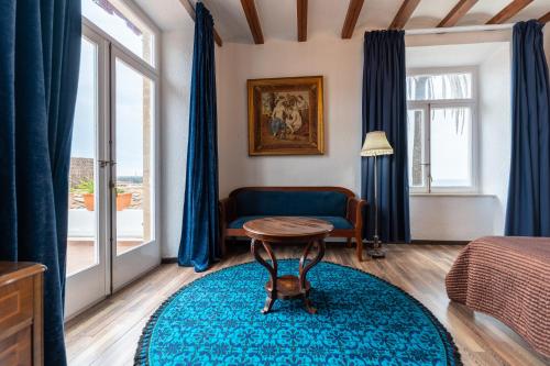 a bedroom with blue curtains and a blue rug at Hotel Roger de Flor by Seleqtta in Lloret de Mar