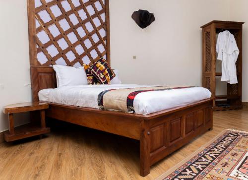 a bed with a wooden frame in a room at Forest Park Resort in Buloba
