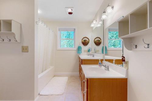 a bathroom with two sinks and a mirror at The Ski Lodge in Ossipee