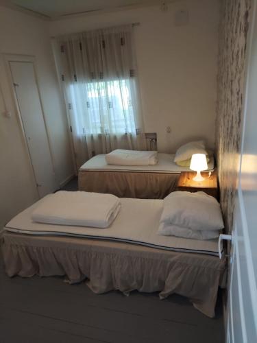 due letti in una piccola stanza con una finestra di Willa Vitsari n60m2 a Kokkola