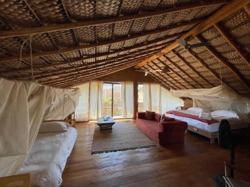 an attic room with two beds and a couch at Eco Lodge Mancora in Máncora