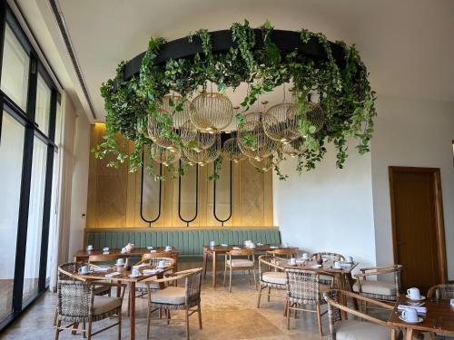 a dining room with tables and chairs and a chandelier at Hotel Mundo Maya Edzná in Nohyaxché