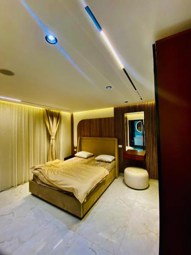 a bedroom with a large bed and a mirror at Luxury 3 bedroom apartment in Banī Ghālib