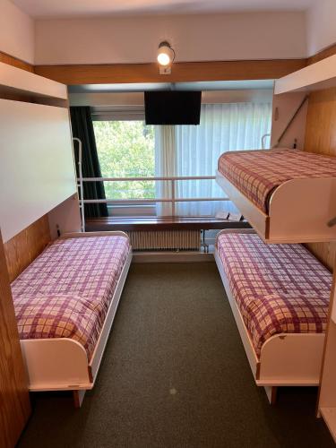 two beds in a room with a window at Residenza Albaré in Marilleva