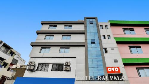a tall white building with a sign on it at Collection O Hotel Raj Palace in Vadodara