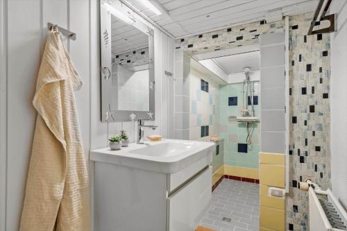 ein weißes Badezimmer mit Waschbecken und Dusche in der Unterkunft 8817 Hvide Sande - Mågevej 2 in Hvide Sande