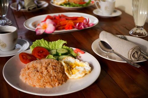 a wooden table with plates of food on it at Uma rerama in Ubud