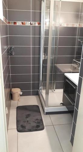 a bathroom with a shower and a black rug at Soleil d'or à St Aygulf in Fréjus