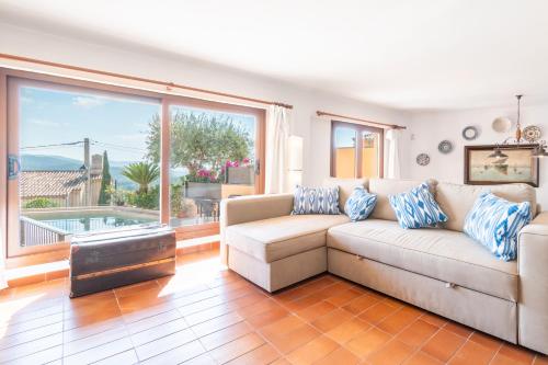 a living room with a couch and a large window at Can Vidal in Campanet
