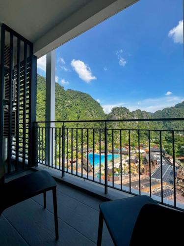 a balcony with a view of a pool and mountains at Sunway Onsen Ipoh by EUcation Home in Tambun