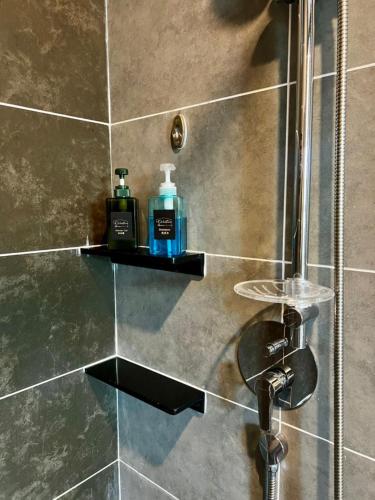 a bathroom with a shower with a bottle of soap at Sunway Onsen Ipoh by EUcation Home in Tambun