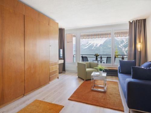 a living room with a blue couch and a table at Apartment Promenade Apt 407 by Interhome in Arosa