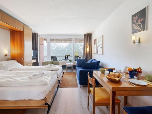 a hotel room with a bed and a dining room at Apartment Promenade Apt 407 by Interhome in Arosa