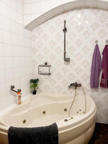 a white bath tub in a bathroom with purple towels at Pension Bergmann-Welp in Freiberg