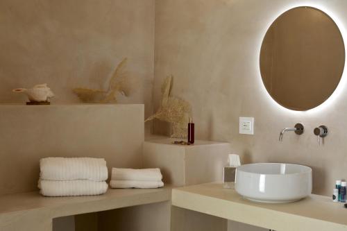 a bathroom with a sink and a mirror and towels at I Bastioni San Domenico - Boutique Hotel in Gallipoli