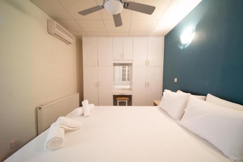 a large white bed in a room with a ceiling fan at Casa Piedra, Hidden Gem, Jacuzzi, BBQ, Patio in Monagroulli in Monagrulli